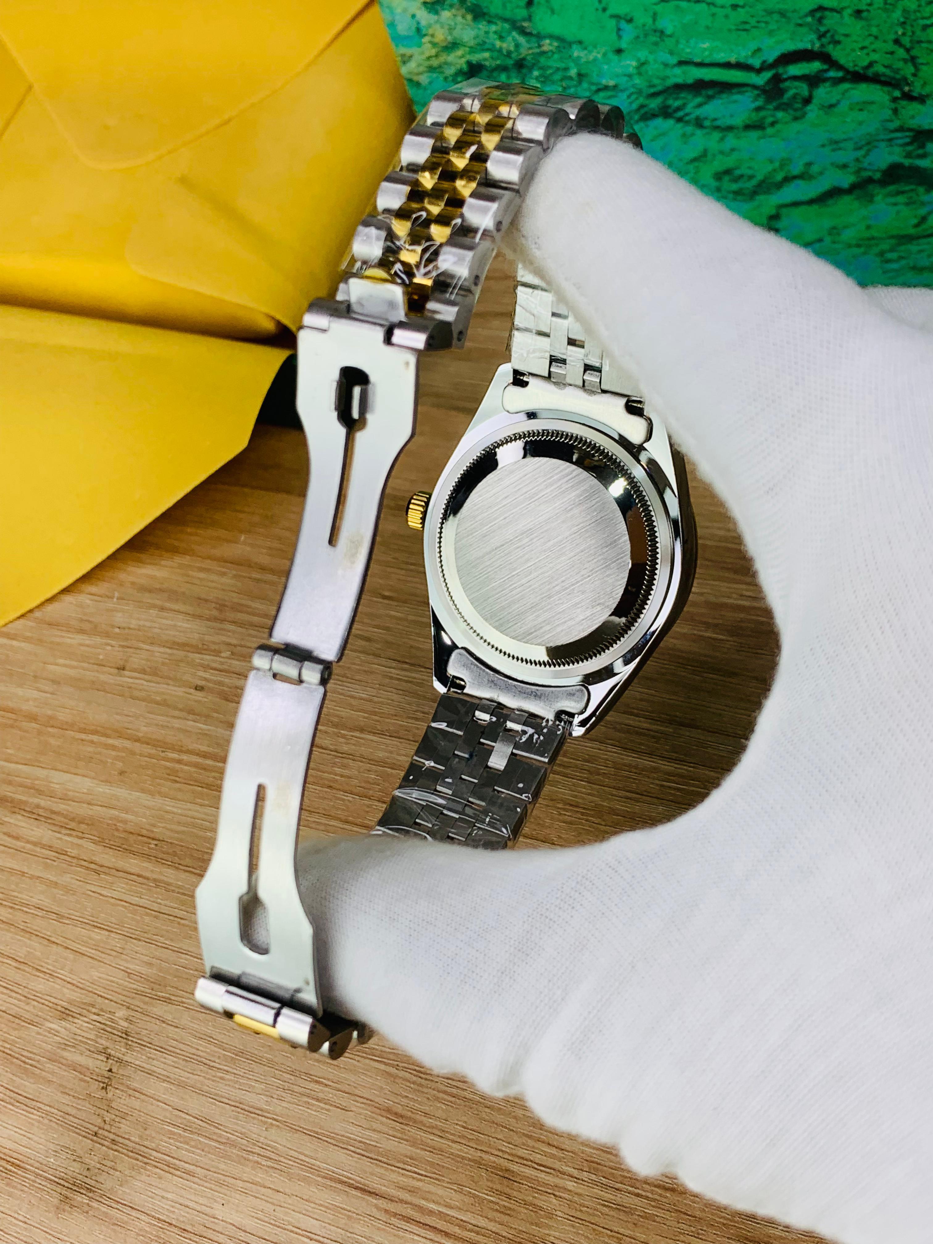 Back lock view of two-tone stainless steel jubilee chain watch with blue stone dial